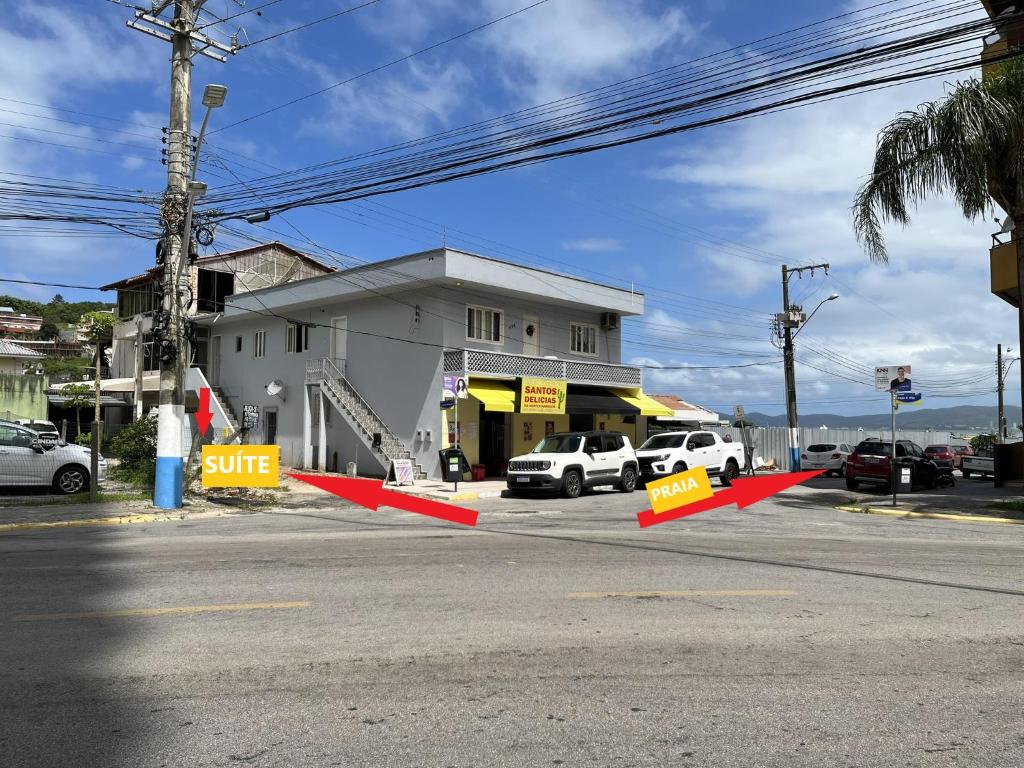 une rue avec panneaux orange devant un bâtiment dans l'établissement Hospedagem 20m da praia., à Itapema