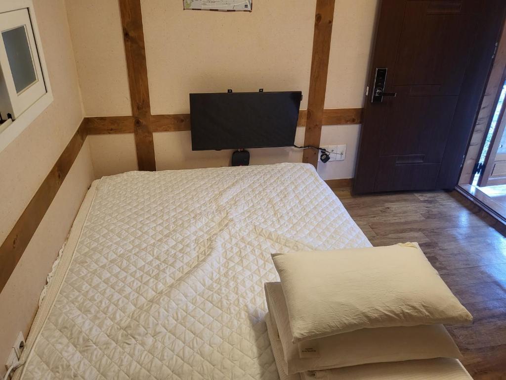 a bedroom with a bed and a flat screen tv at Dasan House in Jeonju