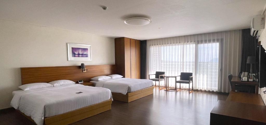 Postel nebo postele na pokoji v ubytování Jeju Aerospace Hotel