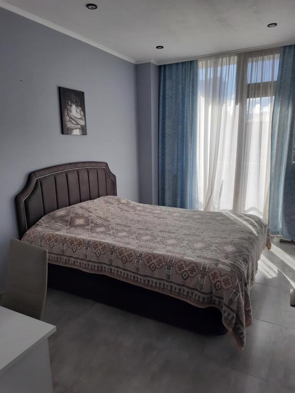 a bedroom with a bed and a large window at Holiday apartment Kobuleti in K'obulet'i