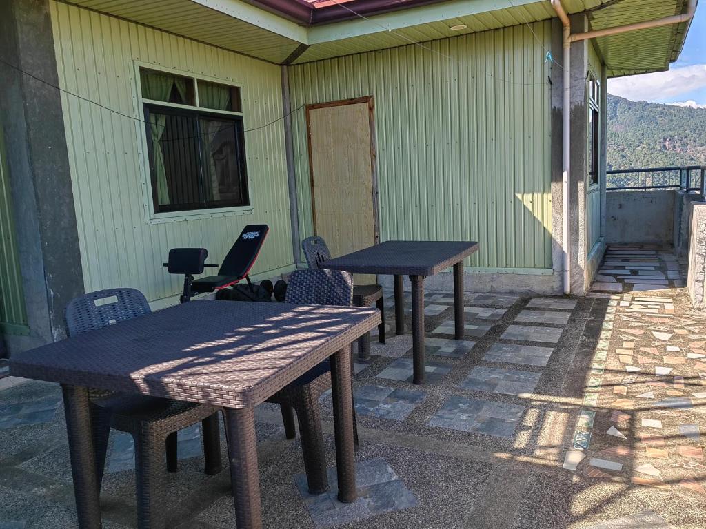 due tavoli da picnic e sedie su un patio di Sea of clouds view inn a Sagada