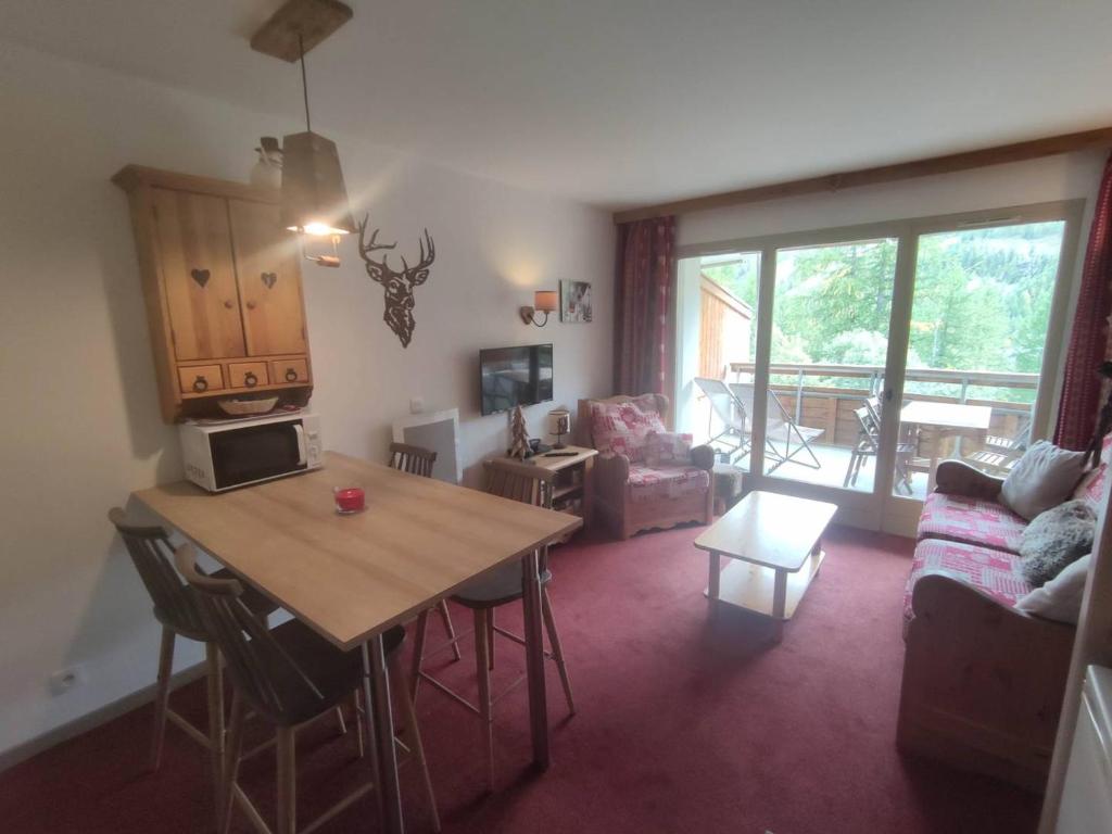 Una cocina y una sala de estar con una mesa y un sofá. en Appartement rénové 2 pièces, 4 pers. à Isola 2000, proche pistes - FR-1-292-215, en Isola