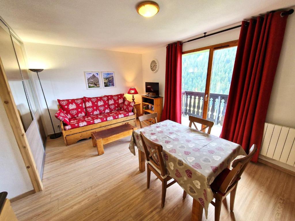 un salon avec un canapé rouge et une table dans l'établissement Apt 6/8 pers, 2 pièces, cabine, cœur de Valfréjus, WiFi, animaux admis - FR-1-265-354, à Modane