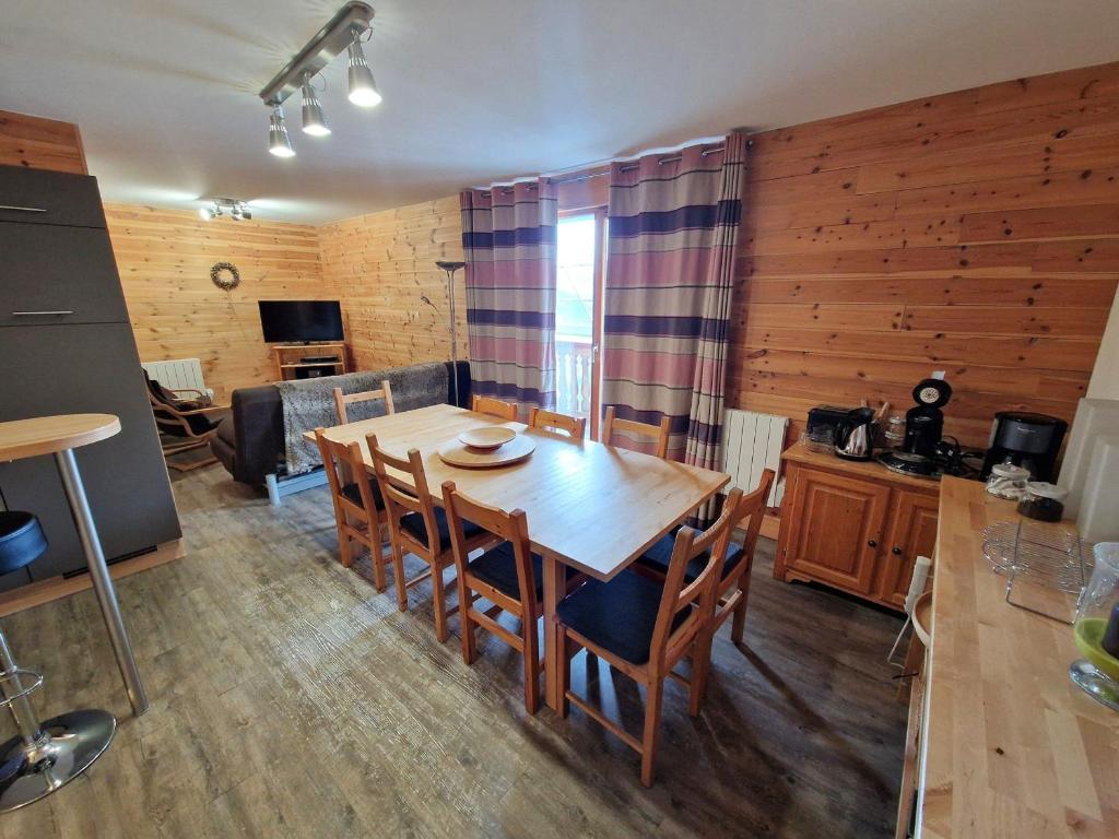 une cuisine et une salle à manger avec une table et des chaises en bois dans l'établissement Appartement spacieux 8 pers, cœur de Valfréjus - FR-1-265-351, à Modane