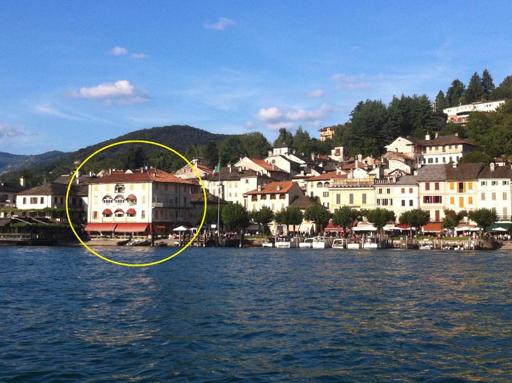 a yellow circle on the water next to a city at -Ortaflats- Appartamenti Imbarcadero & Palazzotto in Orta San Giulio