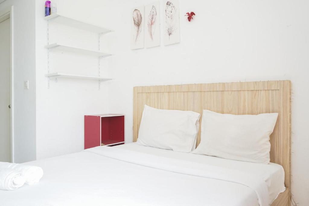 a bedroom with a bed with white sheets and white pillows at Fully Furnished with Cozy Design Studio Poris 88 Apartment By Travelio in Tangerang