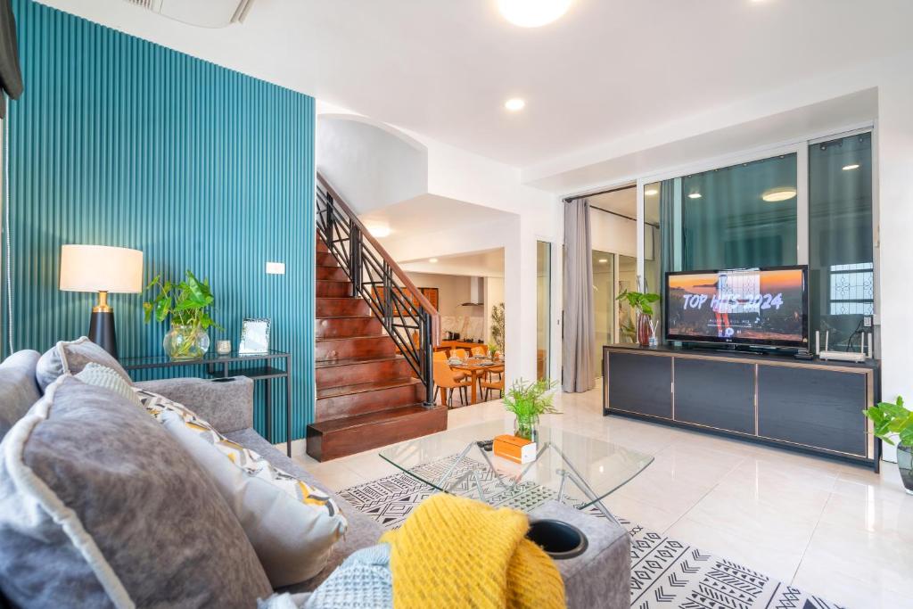 a living room with a couch and a tv at Cozystay Center of Patong near Bangla Road in Patong Beach
