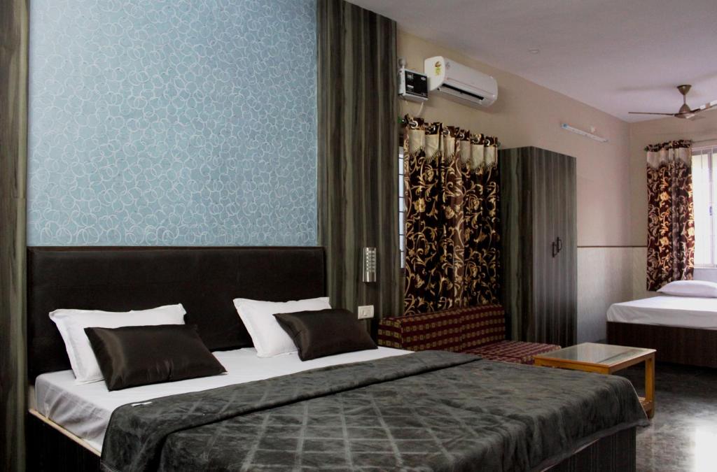 una camera con un grande letto e una parete blu di Vinodhara Guest House a Mamallapuram
