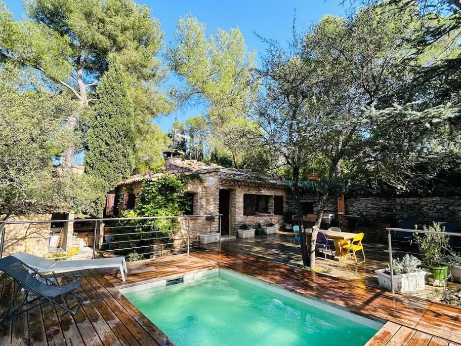 une maison avec une piscine sur une terrasse en bois dans l'établissement Lou Mazet - Nîmes, à Nîmes