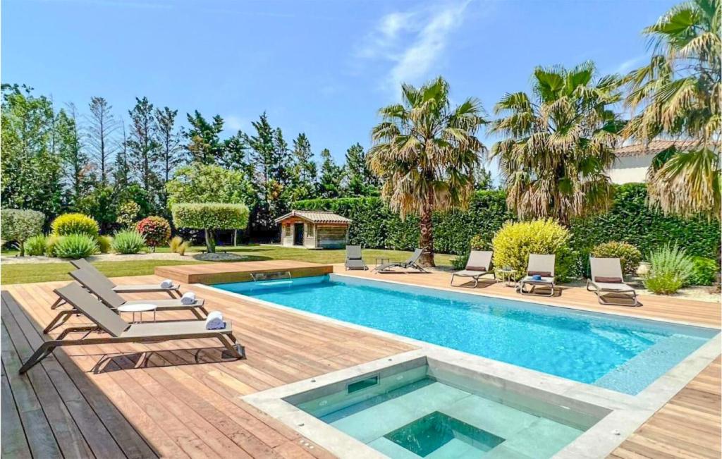 a swimming pool with two lounge chairs and a swimming pool at Cozy Home In Maillane With Kitchen in Maillane