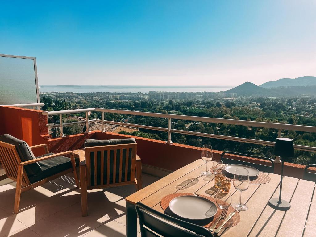 - un balcon avec une table et des verres à vin dans l'établissement La Terrasse de l'Esterel, à Mandelieu-la-Napoule