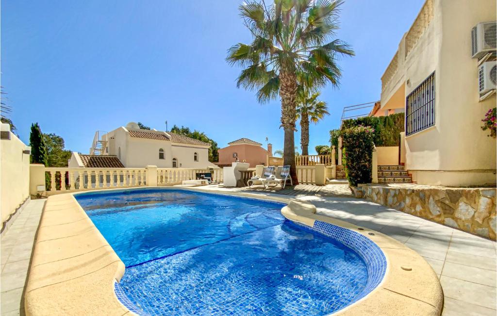 une piscine devant une maison avec un palmier dans l'établissement Beautiful Home In Orihuela Costa, à Orihuela Costa