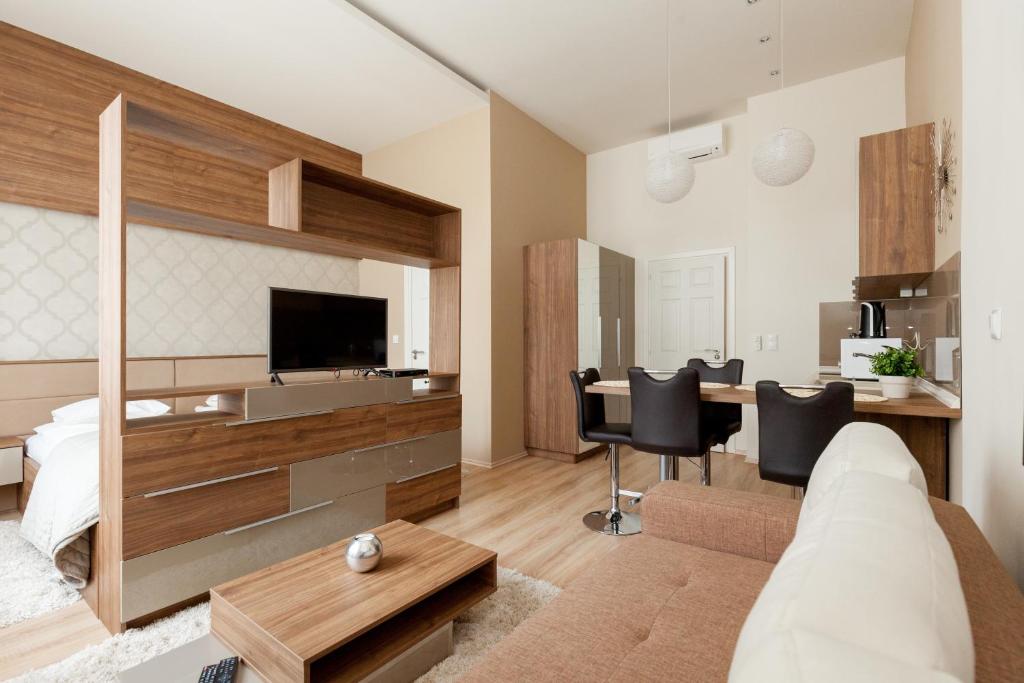 a living room with a bed and a desk with chairs at Holidays Concept in Budapest