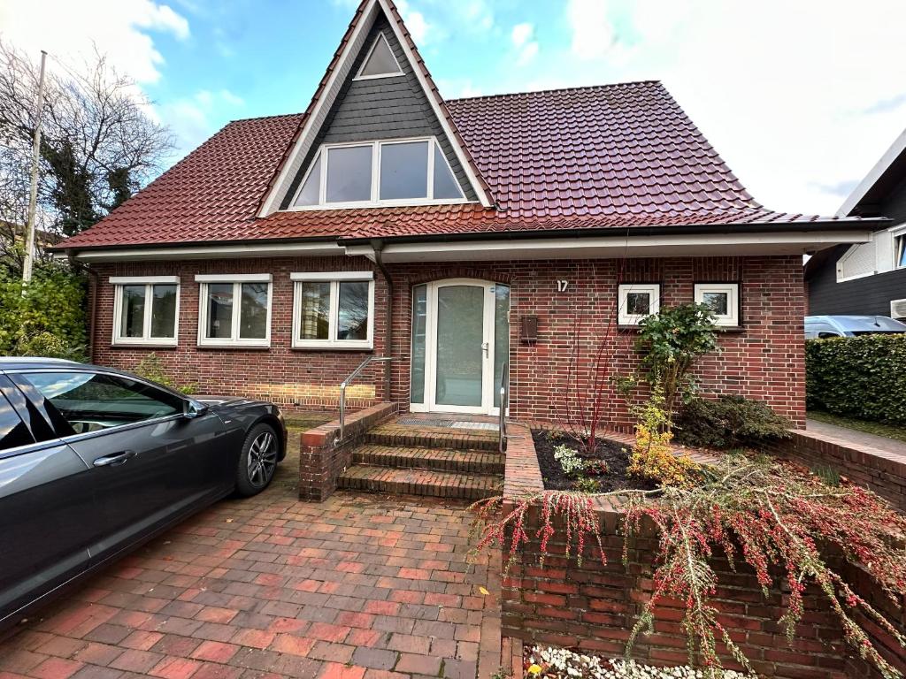 a brick house with a car parked in front of it at Ferienhaus Im Alten Hof in Bad Zwischenahn
