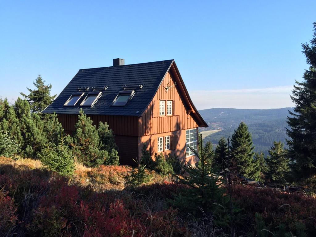 ein Haus mit Sonnenkollektoren auf einem Hügel in der Unterkunft Die Adlerhütte in Kurort Oberwiesenthal