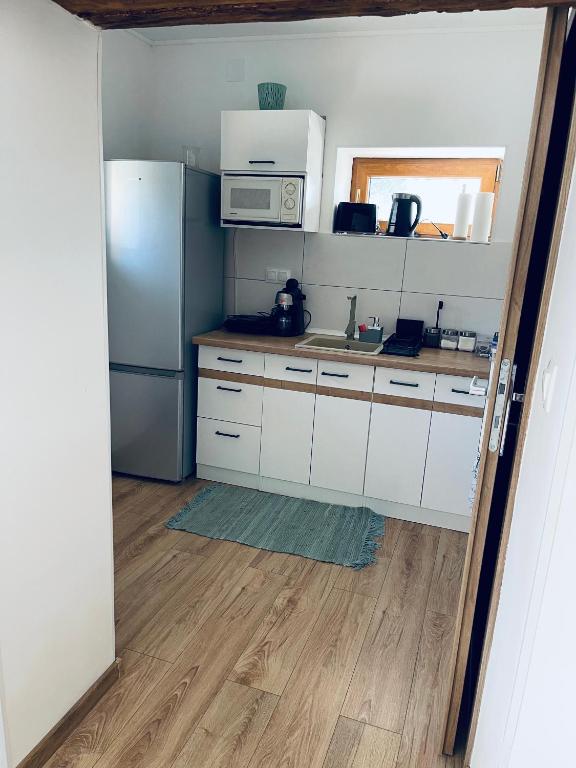 kuchnia z białymi szafkami i lodówką w obiekcie Kaland apartman II. w mieście Sátoraljaújhely