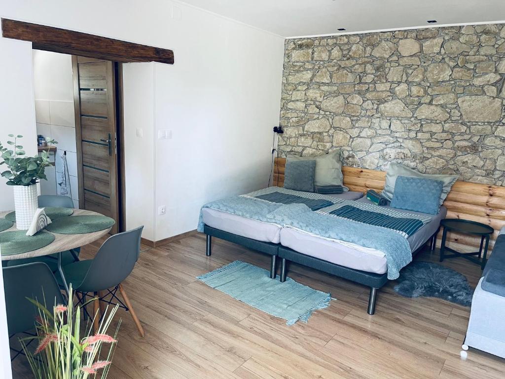 sypialnia z łóżkiem i kamienną ścianą w obiekcie Kaland apartman II. w mieście Sátoraljaújhely