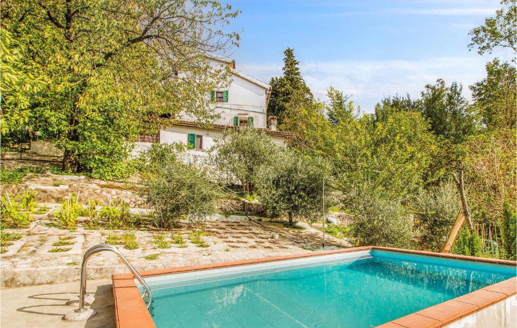 an outdoor swimming pool in front of a house at Three-Bedroom Holiday Home In Santagata Feltria Rn in SantʼAgata Feltria