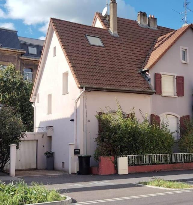 une maison blanche avec un toit marron dans une rue dans l'établissement Villa Jasmin Thionville, à Thionville