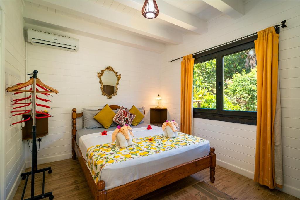 a bedroom with a bed with two stuffed animals on it at Lemongrass Lodge in Beau Vallon
