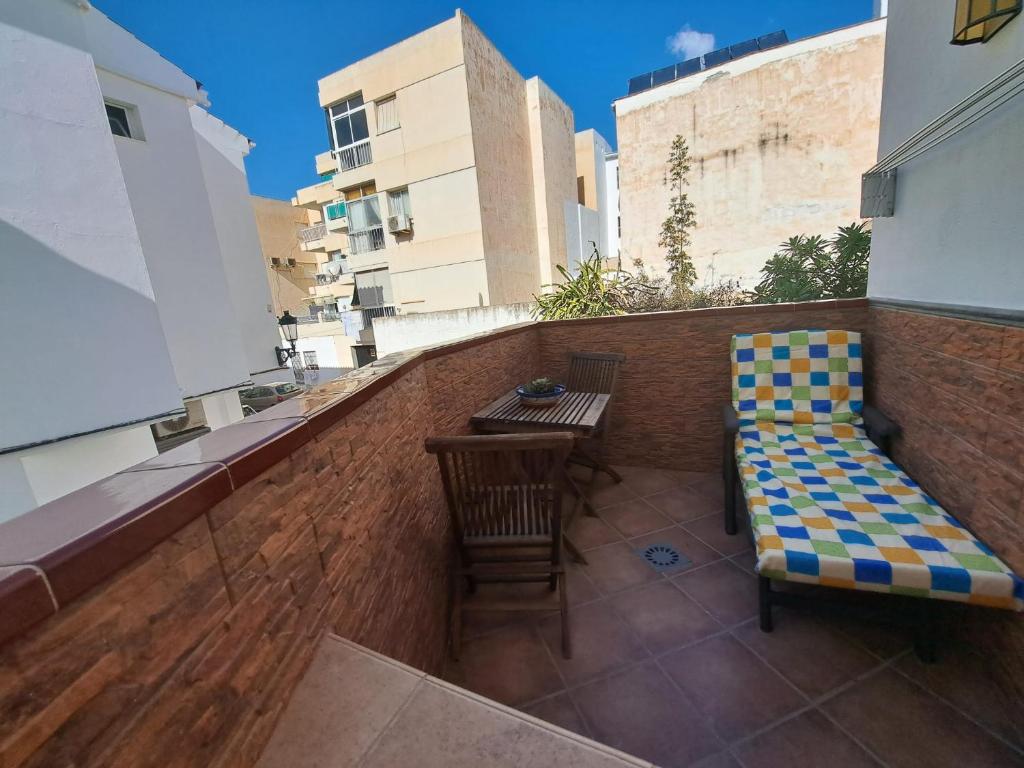 a balcony with a bench and a table on a building at Apartamento Lola 1 in Nerja