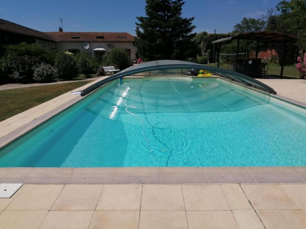 a large swimming pool with a blue water at Logis Gascons in Saint-Justin