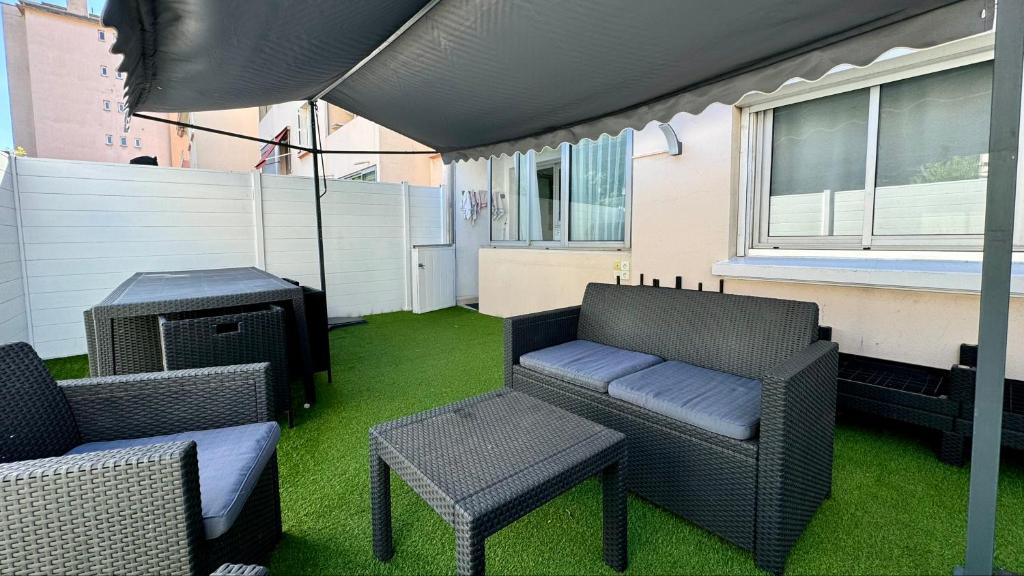 un patio avec des chaises, une table et un grill dans l'établissement Appartement 3 pièces - Proche Centre Cannes, à Cannes