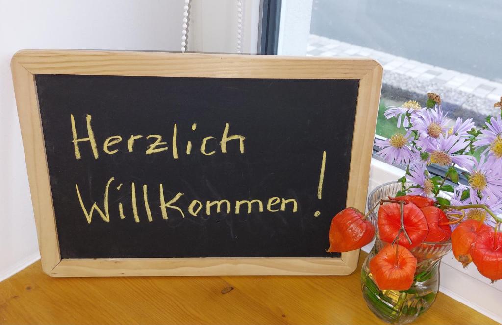 a chalkboard with the words liberalism will kommen next to a vase at Ferienwohnung N plus B in Mitwitz
