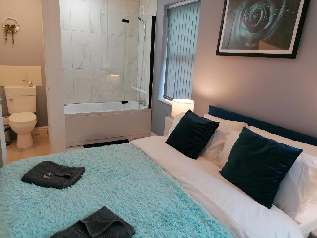 a bedroom with a bed and a tub and a bathroom at Blok 3 -Jacuzzi Suites, Apartment & Ensuite Rooms in Blackpool