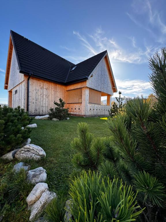 a large wooden house with a black roof at SOPA Zakopane in Zakopane