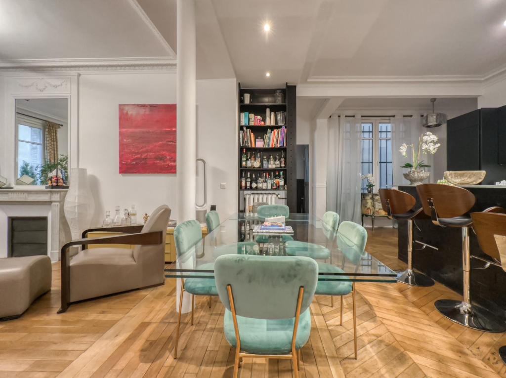 un salon avec une table en verre et des chaises dans l'établissement Luxury Place near Champs Elysees, à Paris