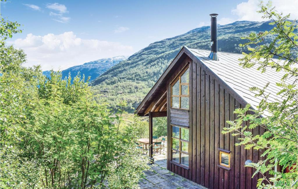 a wooden house with mountains in the background at Four-Bedroom Holiday Home In Roldal in Røldal