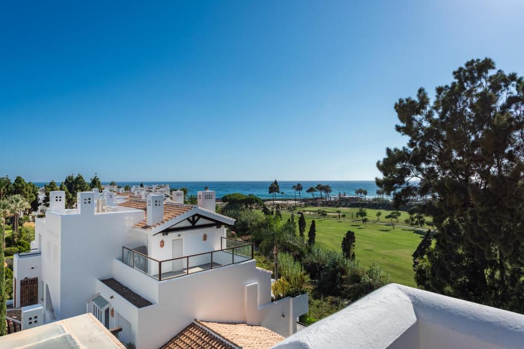 a white house with a view of the ocean at Palm Beach Frontline Penthouse in Marbella