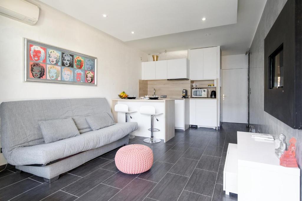 un salon avec un canapé et une cuisine dans l'établissement Le Palm Beach - Croisette - Plage - Casino - Wifi, à Cannes