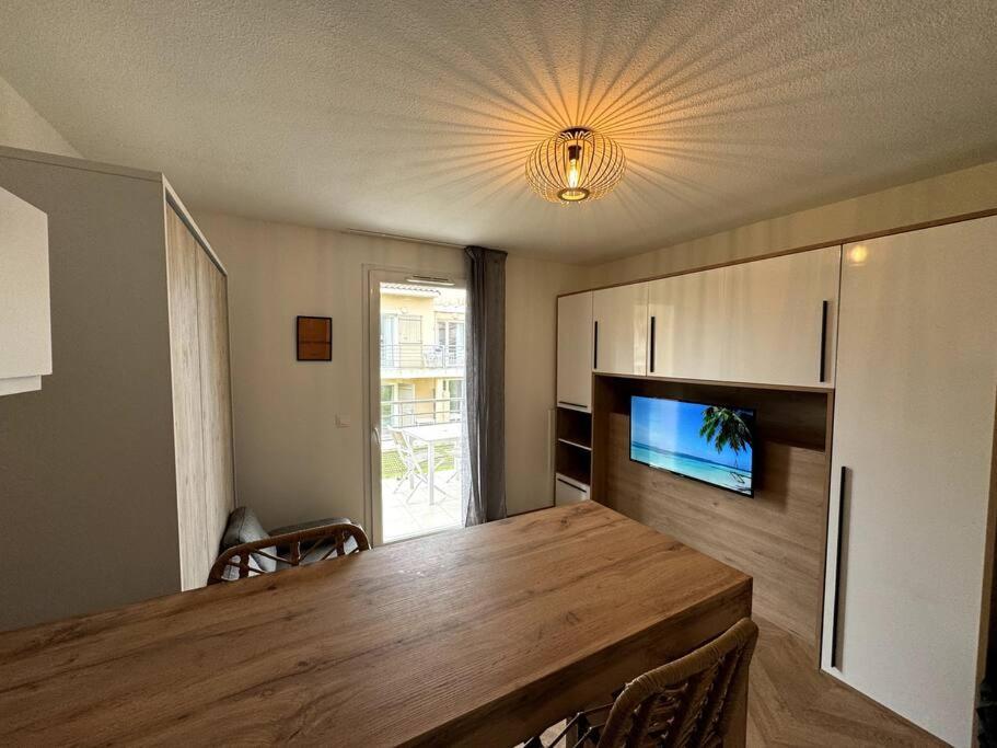 une salle à manger avec une grande table en bois et une télévision dans l'établissement Sharm El-Sheikh, Studio de vacances, à La Londe-les-Maures