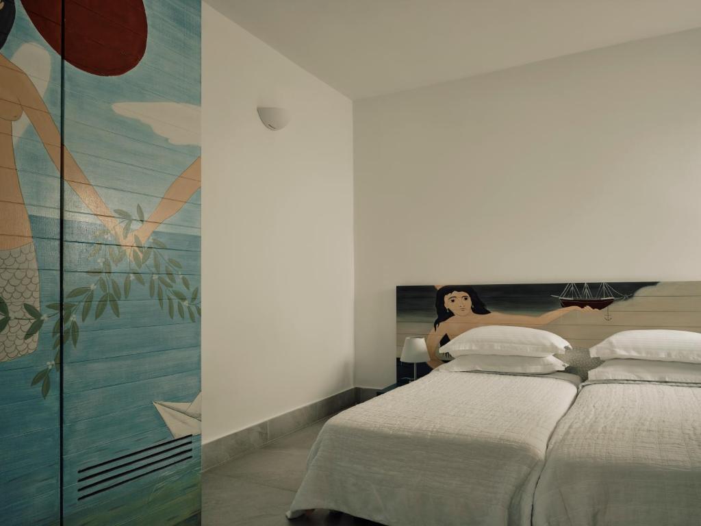 a bedroom with a bed and a mural of a woman at Acteon Hotel in Ios Chora