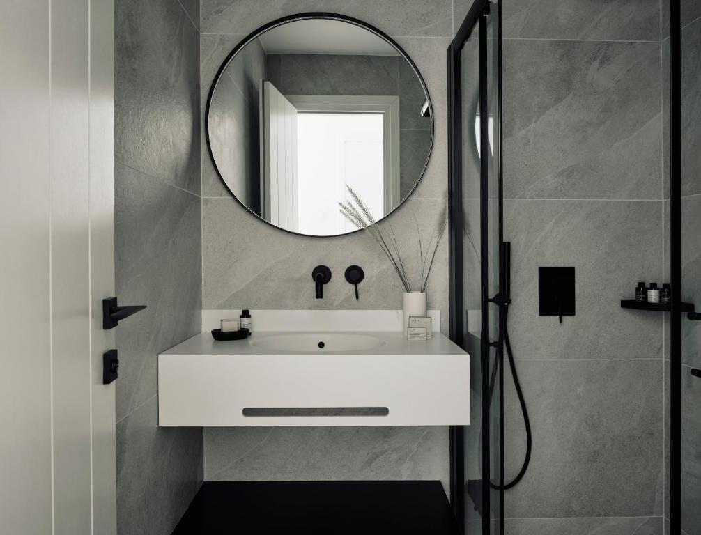 a bathroom with a white sink and a mirror at Acteon Hotel in Ios Chora