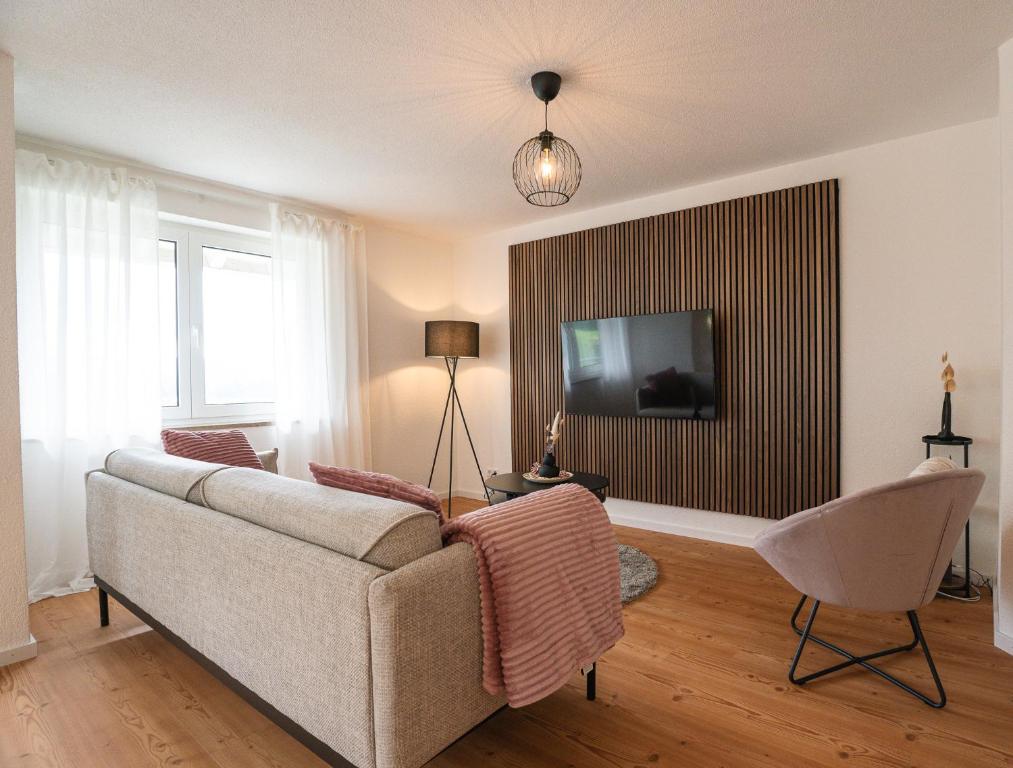 een woonkamer met een bank en een tv bij Wohnung im Rheintal in Küssaberg