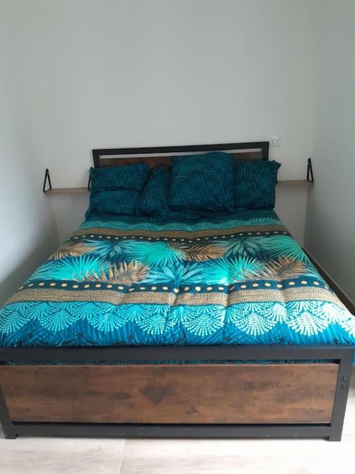 - un lit avec une couette et des oreillers bleus dans l'établissement Charmant appartement au calme, à Gilhoc sur Ormeze