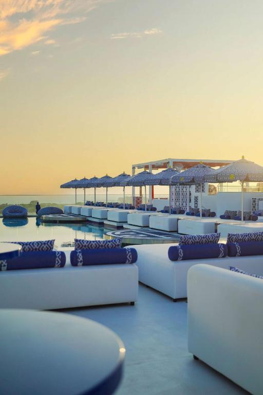 a row of lounge chairs and umbrellas on a beach at Radisson Beach Resort Palm Jumeirah in Dubai