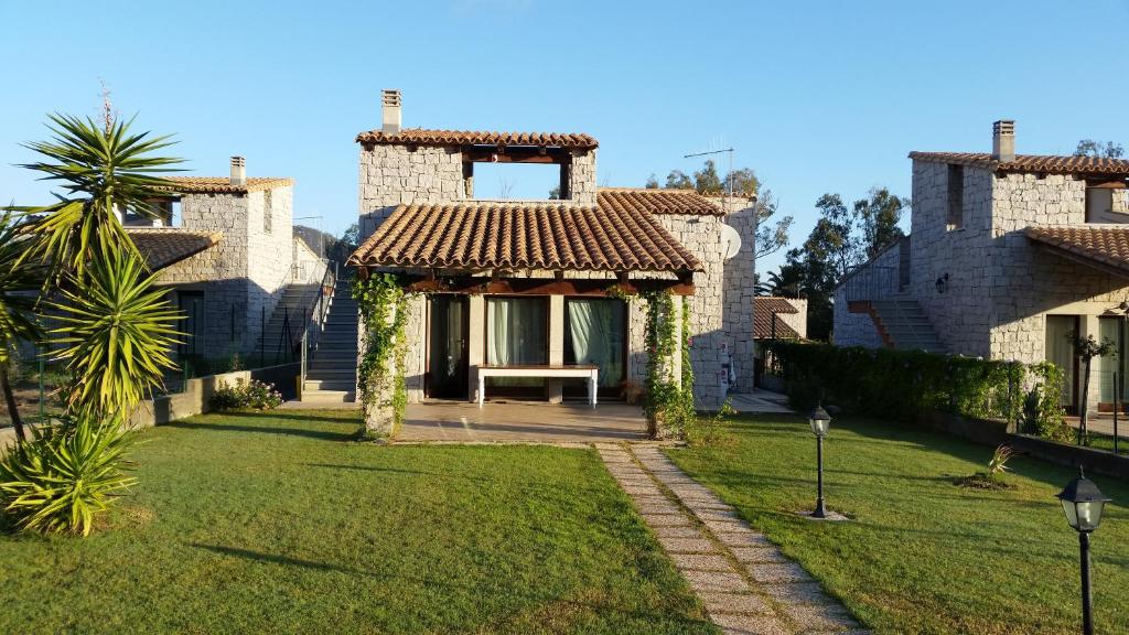 una casa con una panchina nel cortile di Villa Cala Sinzias a Castiadas