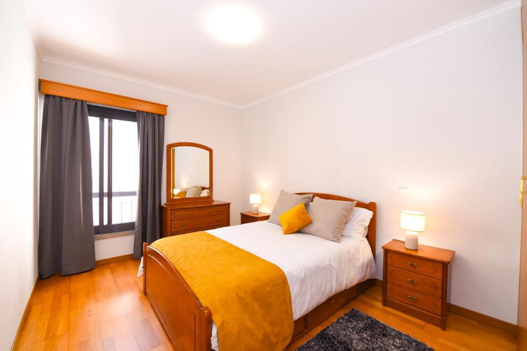 a bedroom with a bed and a mirror and a window at Farinha's Apartment in Ribeira Brava