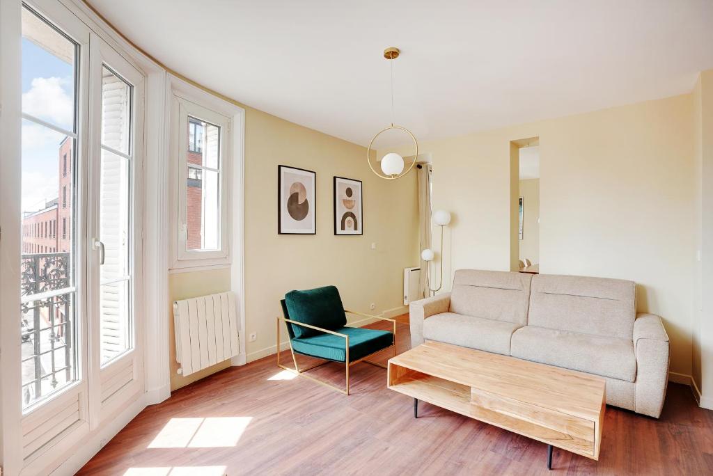 un salon avec un canapé et une chaise dans l'établissement Pick A Flat's Apartment in Saint-Ouen - Rue des Rosiers, à Saint-Ouen