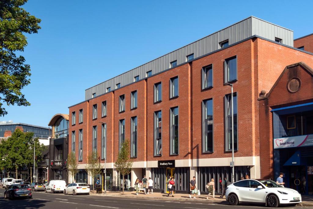 a red brick building on a street with cars parked on the street at Bradbury Place in Belfast