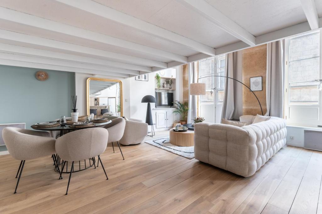 un salon avec une table, des chaises et un canapé dans l'établissement MDOR - Atoll - Appt au cœur de Lyon, à Lyon
