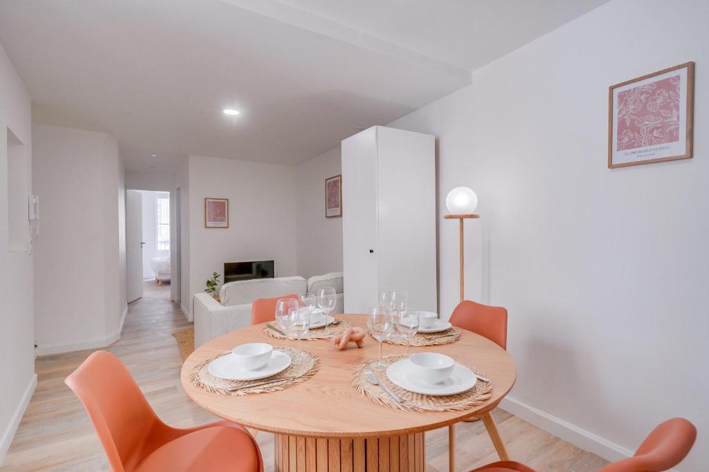 une salle à manger avec une table et des chaises en bois dans l'établissement MDOR Le Chai - Appt au cœur de Bordeaux, à Bordeaux