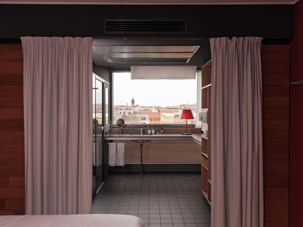 a bedroom with white curtains and a large window at Casa Camper Berlin in Berlin