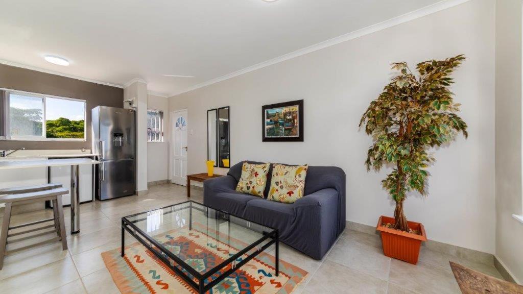 a living room with a couch and a table at Bay Lodge 29 in Ballito