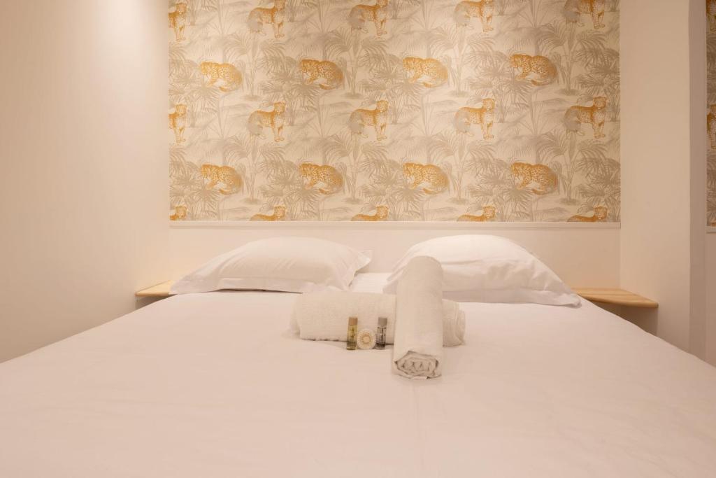 une chambre avec un lit blanc avec des serviettes dessus dans l'établissement Charming studio in Versailles - Welkeys, à Versailles