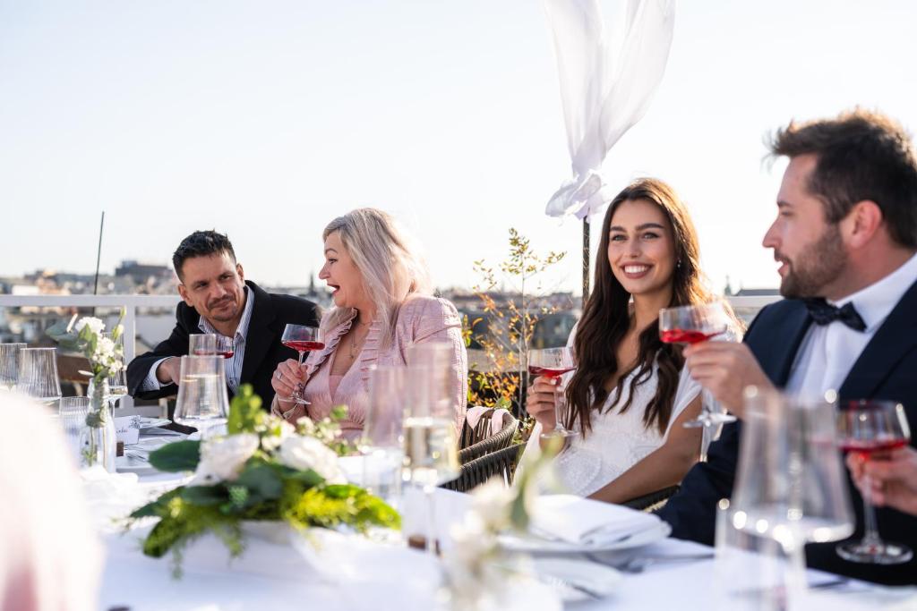 a group of people sitting at a table with wine glasses at Pytloun Boutique Hotel Prague in Prague